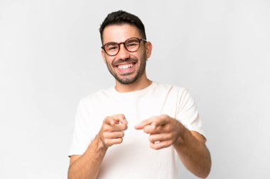 İzole edilmiş beyaz arka planı olan yakışıklı beyaz bir adam öne bakıyor ve gülümsüyor.