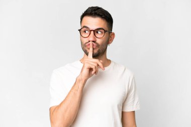 Young handsome caucasian man over isolated white background showing a sign of silence gesture putting finger in mouth