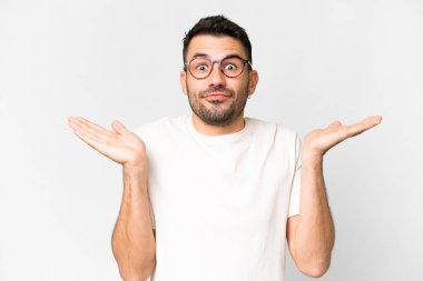 Young handsome caucasian man over isolated white background making doubts gesture clipart