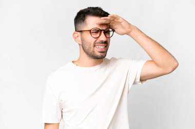 İzole edilmiş beyaz bir geçmişi olan yakışıklı beyaz bir adam bir şeye bakmak için uzaklara bakıyor.