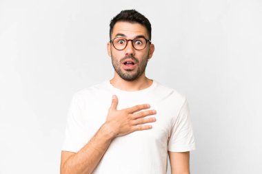 Beyaz arka planda yaşayan yakışıklı beyaz adam sağa bakarken şaşırdı ve şok oldu.