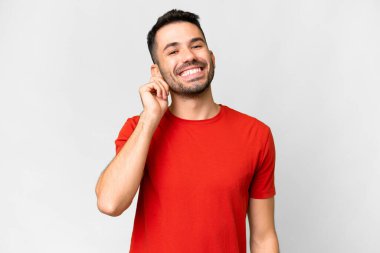 Soyutlanmış beyaz arka planda gülen yakışıklı beyaz bir adam.