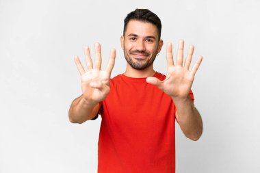Beyaz arka planda beyaz tenli yakışıklı bir adam dokuz parmaklı sayıyor.