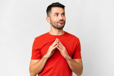 Genç yakışıklı beyaz adam izole edilmiş beyaz arka planda bir şeyler çeviriyor.