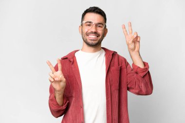 İzole edilmiş beyaz arka planı olan yakışıklı beyaz bir adam zafer işareti gösteriyor.