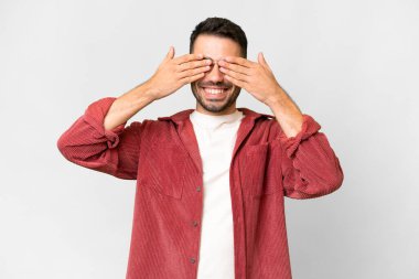 İzole edilmiş beyaz arka planda genç, yakışıklı, beyaz bir adam. Gözleri kapalı ve gülümsüyor.