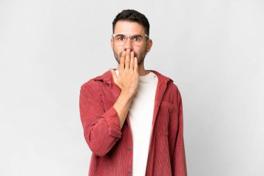 İzole edilmiş beyaz arka planı olan yakışıklı, beyaz bir adam. Ağzını eliyle kapatıyor.