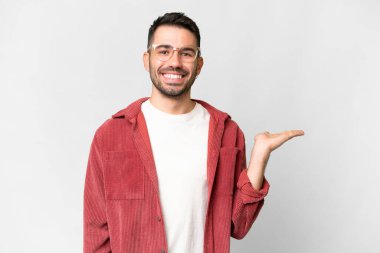 İzole edilmiş beyaz arka plan üzerinde yakışıklı beyaz bir adam bir ilan vermek için fotokopi makinesini avucunun içinde tutuyor.