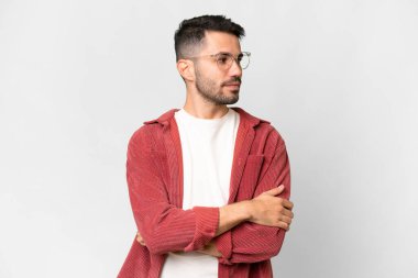 İzole edilmiş beyaz arka planı olan yakışıklı beyaz bir adam kollarını kavuşturuyor.