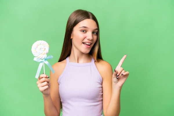 stock image Teenager caucasian girl holding a lollipop over isolated background intending to realizes the solution while lifting a finger up