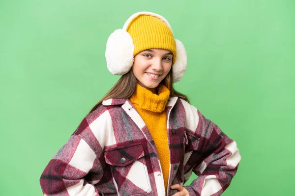 年轻的高加索女孩披着冬衣 背对着孤立的背景 双手叉腰 面带微笑 — 图库照片