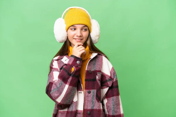 年轻的高加索女孩披着冬衣 背景偏僻 向侧面看去 — 图库照片