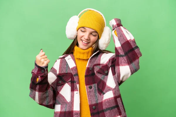 在庆祝胜利的孤立背景下 年轻的高加索女孩戴着冬衣 — 图库照片