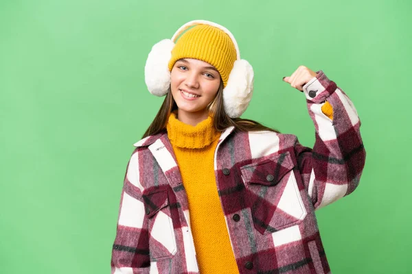 年轻的高加索女孩穿着冬衣 背景孤寂 做着强有力的手势 — 图库照片