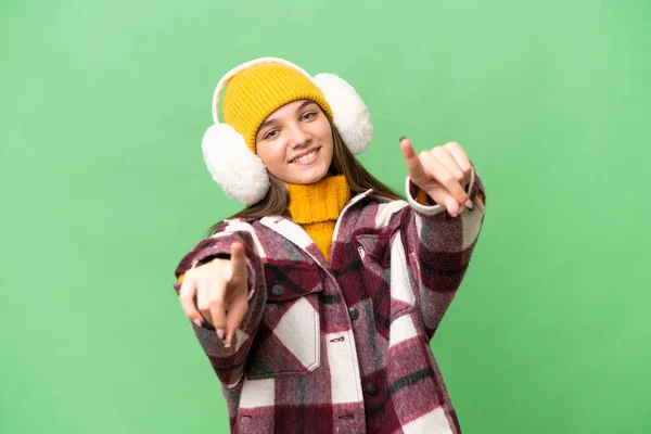 年少无知的高加索女孩 戴着冬衣 带着孤立的背景音乐 微笑着对你指指点点 — 图库照片