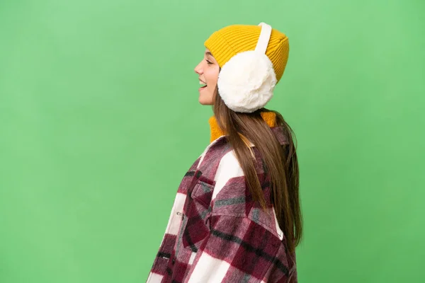 Teenager Kaukasische Mädchen Tragen Wintermuffs Über Isoliertem Hintergrund Lachen Seitlicher — Stockfoto