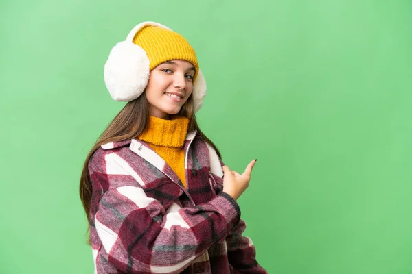 Teenager Caucasian Girl Wearing Winter Muffs Isolated Background Pointing Back — Stock Photo, Image