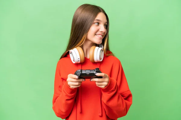 青少年高加索女孩玩电子游戏控制器在孤立的背景图一侧 — 图库照片
