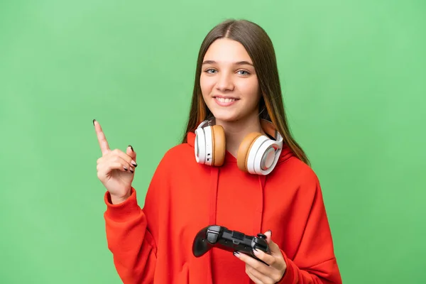 青少年白种人女孩玩电子游戏控制器在孤立的背景下显示和举起一个手指表示最好的标志 — 图库照片