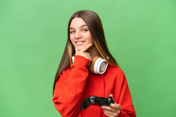 ティーンCaucasian女の子遊びますとともにAビデオゲームコントローラ上の隔離された背景幸せと笑顔 — ストック写真