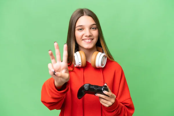 青少年白种人女孩在孤独的背景下快乐地和电子游戏控制器玩耍 用手指数着三个 — 图库照片