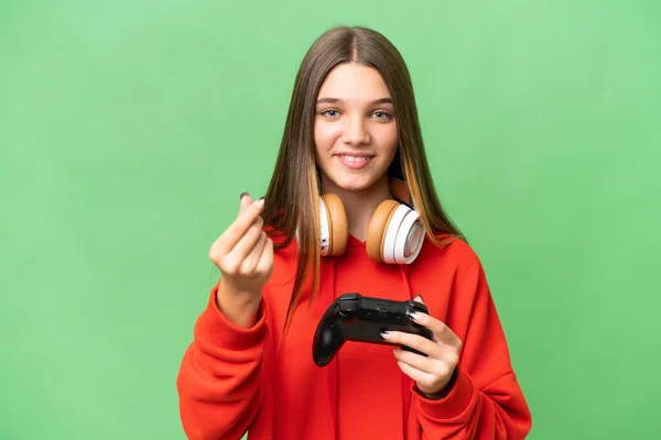 青少年白种人女孩玩电子游戏控制器的时候 背景孤立 做出赚钱的姿态 — 图库照片