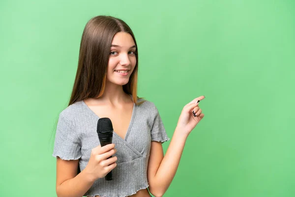 Adolescente Cantante Chica Recogiendo Micrófono Sobre Fondo Aislado Señalando Dedo — Foto de Stock