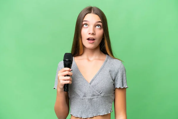 Genç Şarkıcı Kız Izole Edilmiş Bir Arka Planda Mikrofonu Kaldırıyor — Stok fotoğraf
