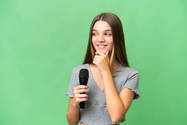 Teenager Singer Girl Picking Microphone Isolated Background Looking Side Smiling — Foto de Stock