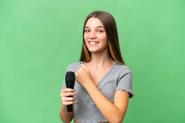 Adolescente Cantante Chica Recogiendo Micrófono Sobre Aislado Fondo Celebrando Una — Foto de Stock