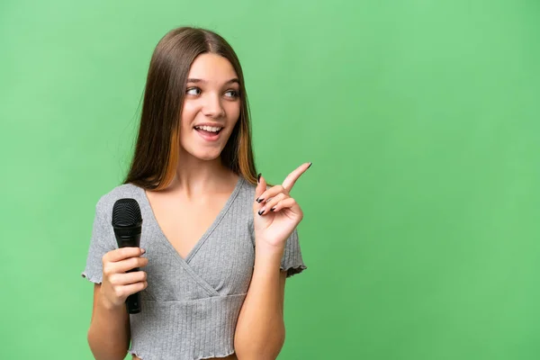 Chica Cantante Adolescente Recogiendo Micrófono Sobre Fondo Aislado Con Intención — Foto de Stock