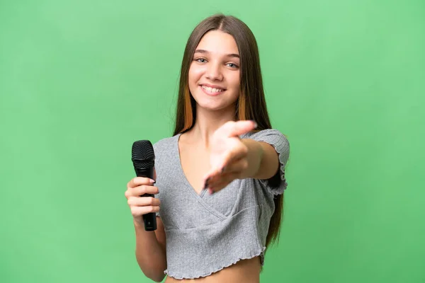 Nastoletnia Piosenkarka Podnosi Mikrofon Nad Odizolowanym Tłem Ściskając Dłonie Zamknięcie — Zdjęcie stockowe