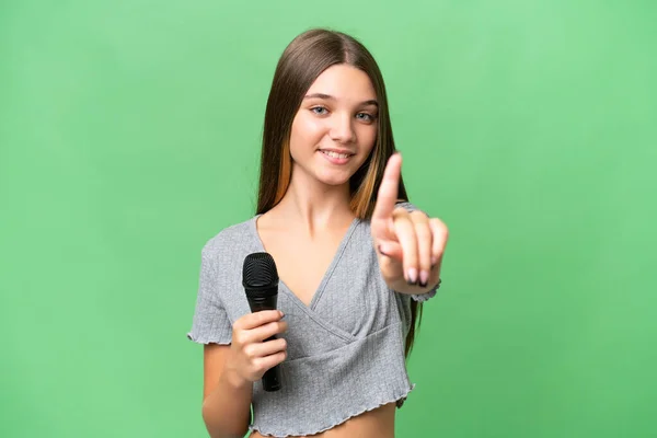 Genç Şarkıcı Kız Izole Edilmiş Bir Arka Planda Mikrofonu Kaldırıyor — Stok fotoğraf