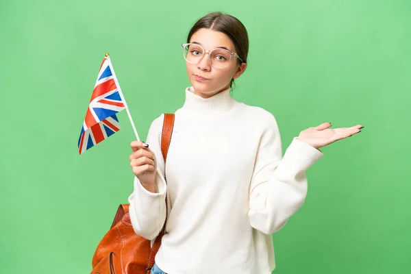 Подростковая Студентка Кавказка Держащая Флаг Великобритании Изолированном Фоне Сомневается Поднимая — стоковое фото