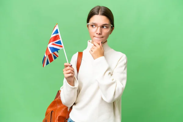 Подростковая Студентка Кавказка Держащая Флаг Великобритании Изолированном Фоне Сомневается Думает — стоковое фото