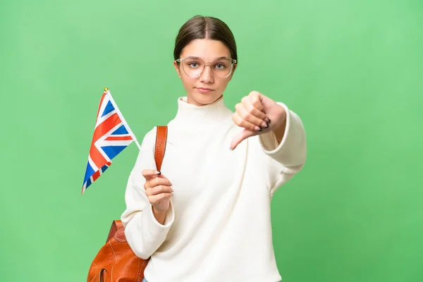 十几岁的学生 高举英国国旗 背景孤立 带着负面表情垂下大拇指的高加索女孩 — 图库照片