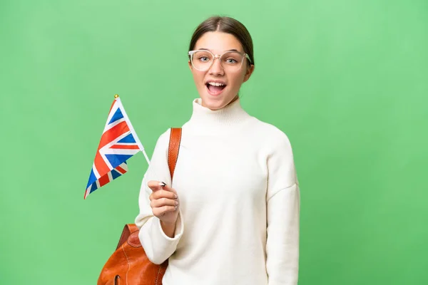 十几岁的学生 高举英国国旗 背景孤立 面部表情令人惊讶的高加索女孩 — 图库照片