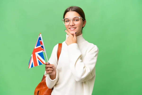 ティーン学生Caucasian女の子保持A英国フラグ上の隔離された背景幸せと笑顔 — ストック写真