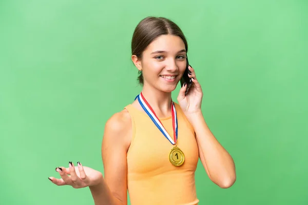 Teenager Běloška Medailemi Nad Izolované Pozadí Vedení Konverzace Mobilním Telefonem — Stock fotografie