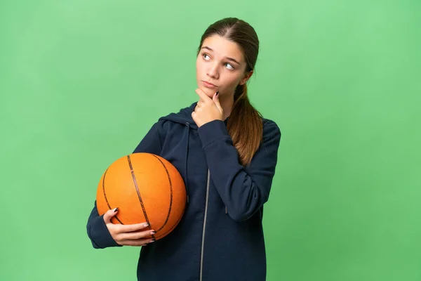 ティーンCaucasian女の子遊びバスケットボール上の隔離された背景持っています疑問 — ストック写真