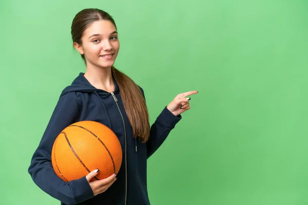 코카서스 소녀가 배경을 가리키며 농구를 — 스톡 사진