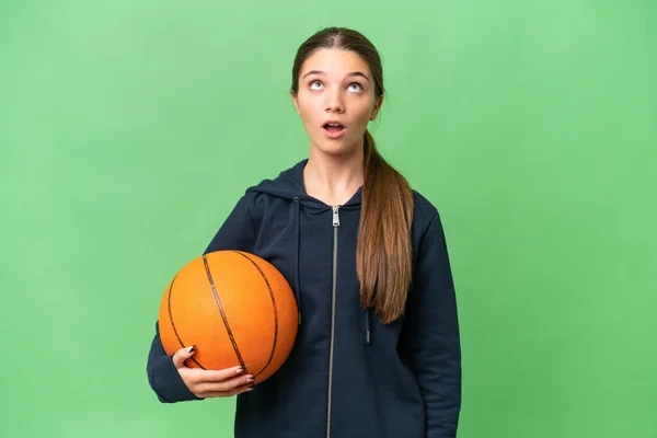 ティーンCaucasian女の子プレイバスケットボール上の隔離された背景を見上げますとともに驚きの表情 — ストック写真