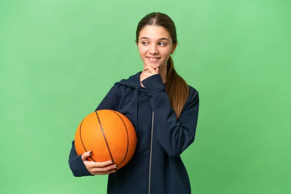 十几岁的白人女孩在与世隔绝的背景下打篮球 看着旁边 微笑着 — 图库照片