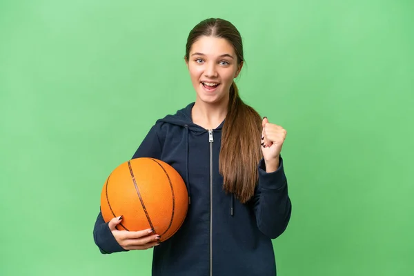 ティーンCaucasian女の子遊びバスケットボール上の隔離された背景祝いますA勝利で勝者の位置 — ストック写真