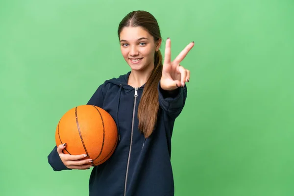 Девушка Кавказка Подросток Играет Баскетбол Изолированном Фоне Улыбаясь Показывая Знак — стоковое фото