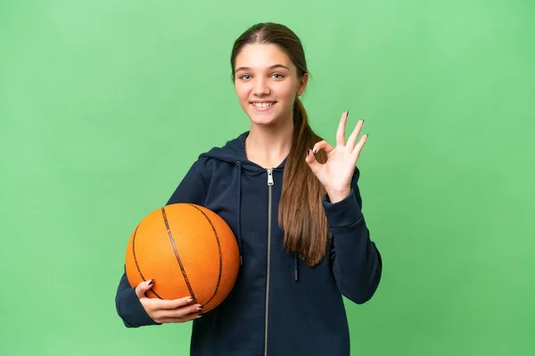 ティーンCaucasian女の子プレイバスケットボール上の隔離された背景ショーOk Signとともに指 — ストック写真