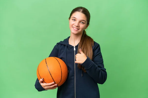 十几岁的白人女孩在孤立无援的背景下打篮球时举起了一个大拇指 — 图库照片