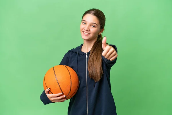 ティーンCaucasian女の子プレイバスケットボール上の隔離された背景とともに親指アップ何か良いことが起こったので — ストック写真