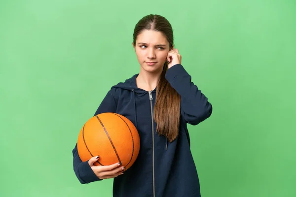 年轻的高加索女孩在孤立无援的背景下打篮球 感到沮丧 并捂住了耳朵 — 图库照片