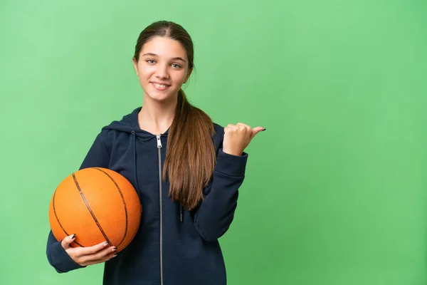 十几岁的白人女孩在一个与世隔绝的背景下打篮球 指着旁边介绍自己的产品 — 图库照片